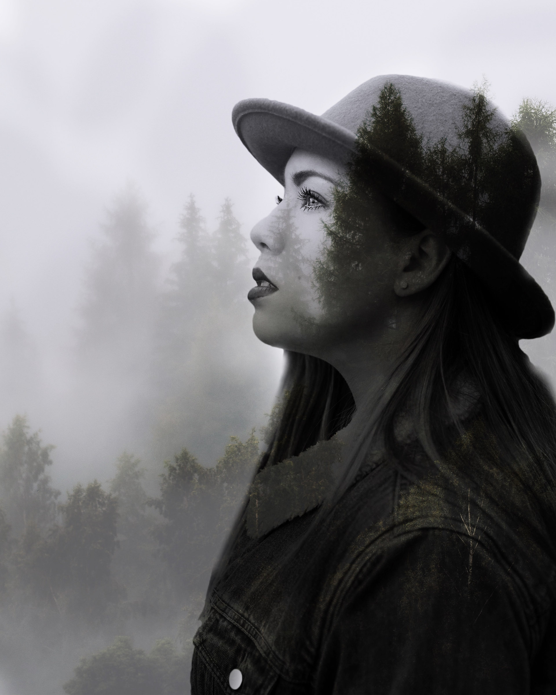 Woman in profile with a double exposure of pine trees