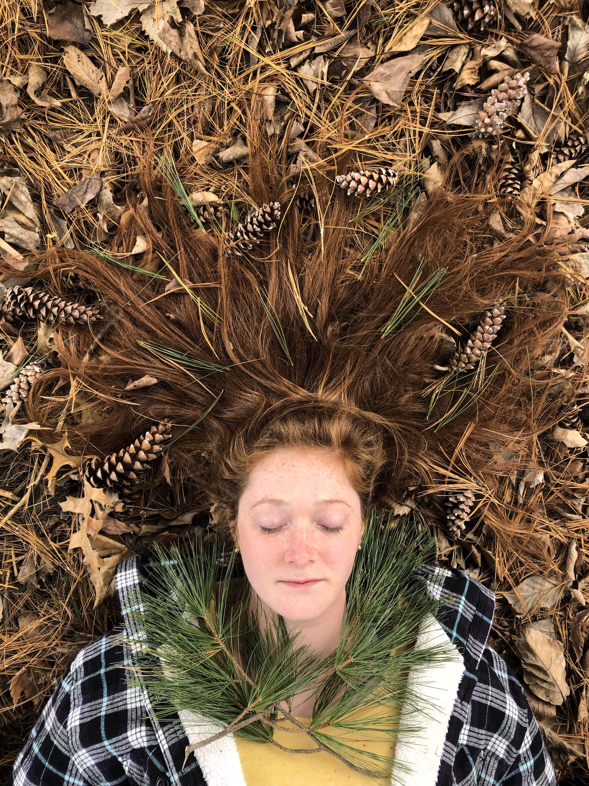 Woman lying on a bed of pine needles