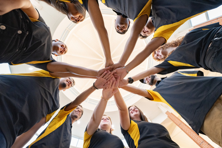 Students with hands together in team like way