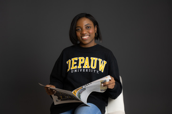 Woman smiling while reading DePauw magazine