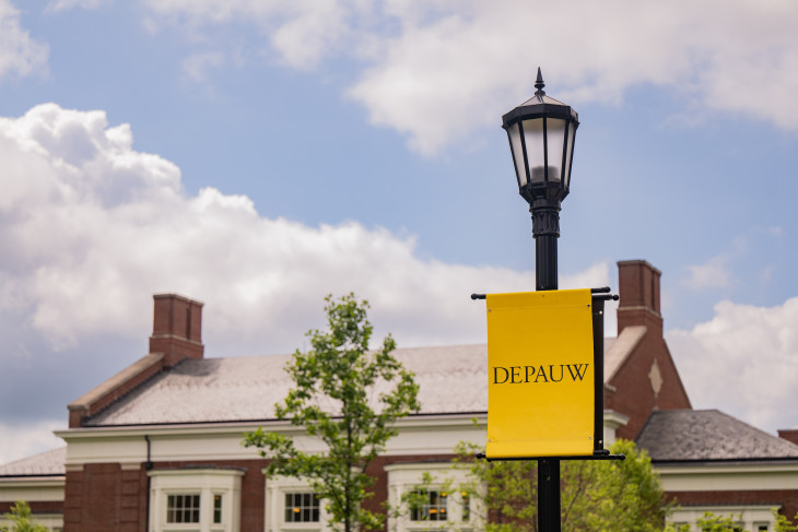 DePauw flag hanging from a light post in front of building