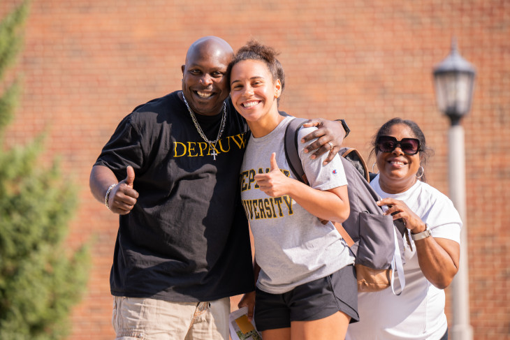 Student posed with her parents, smiling, at move-in