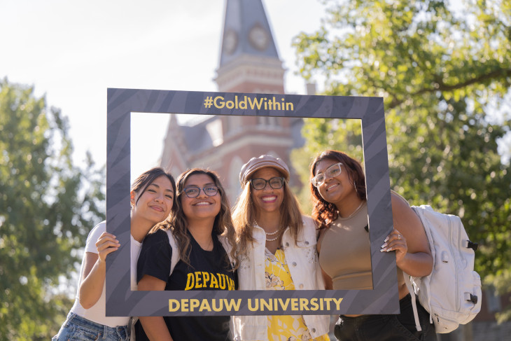 Lori S. White with students on campus together in a DePauw picture frame 