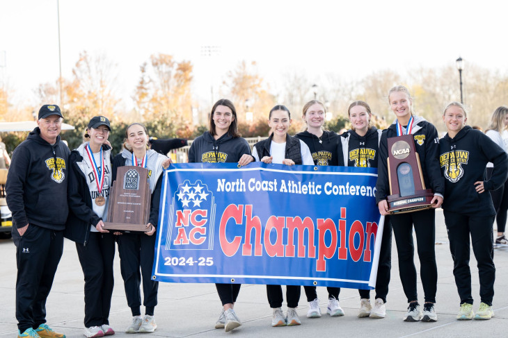 Women's cross country team with conference championship banner