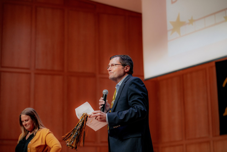 Man presenting a PPT with woman sitting behind