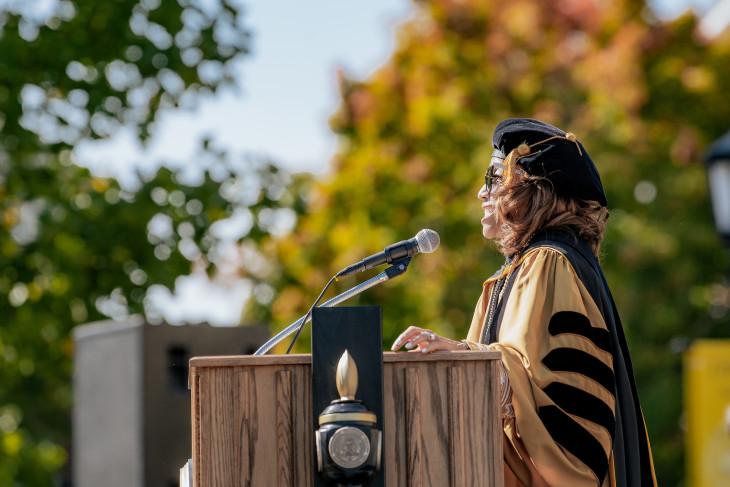 President Lori S. White speaking on the podium during commencement