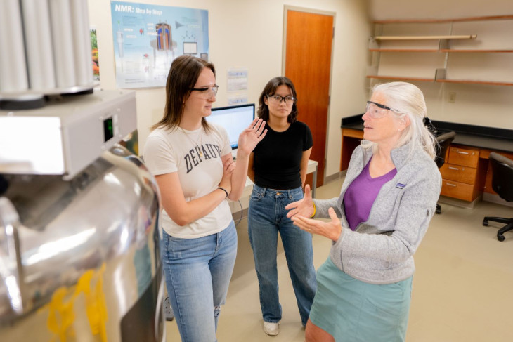 Professor and two students talking together in the lab