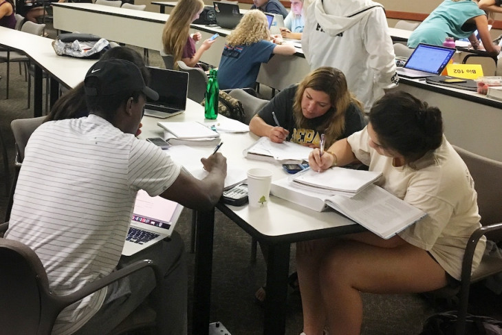 Students study around table