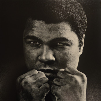 A image of the boxer Muhammad Ali with his fist raised in front of his face