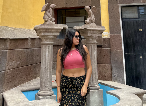 Vanessa standing front of a building framed by two pillars.