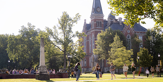 Students walking around campus with East College in the background