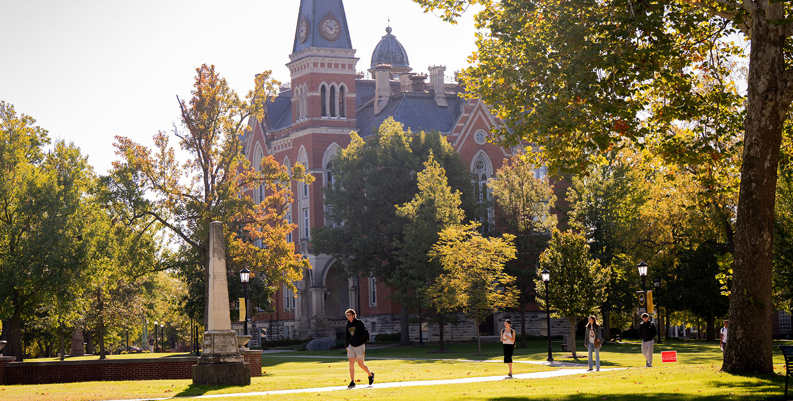 Students walking around campus with East College in the background